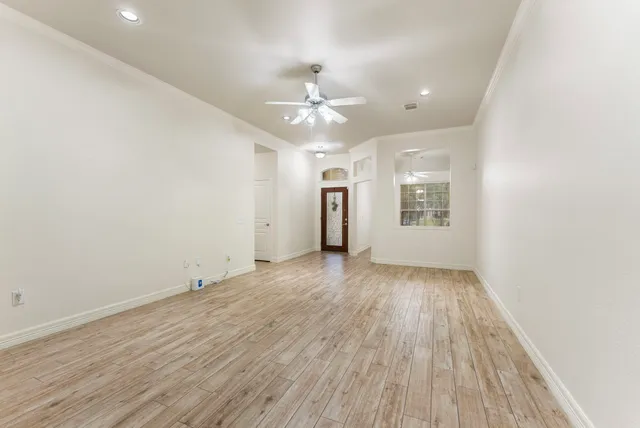 a view of a room with wooden floor chandelier and windows