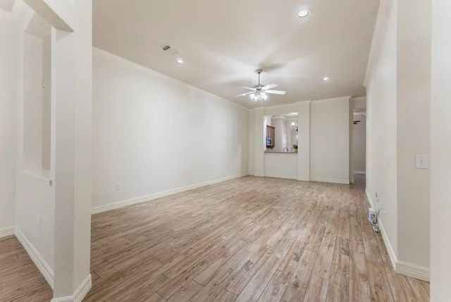 an empty room with a window and a ceiling fan