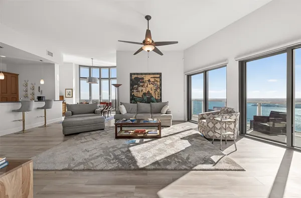 a large kitchen with stainless steel appliances granite countertop a refrigerator a sink dishwasher a stove and white countertops with wooden floor