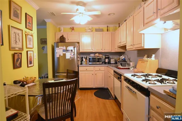 a kitchen with stainless steel appliances granite countertop a stove a sink dishwasher and cabinets with wooden floor