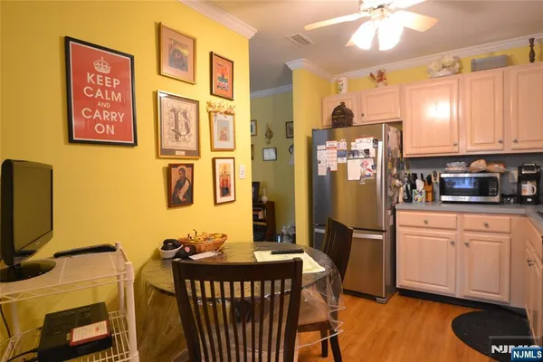 a kitchen with stainless steel appliances granite countertop a stove a refrigerator a dining table and chairs with wooden floor