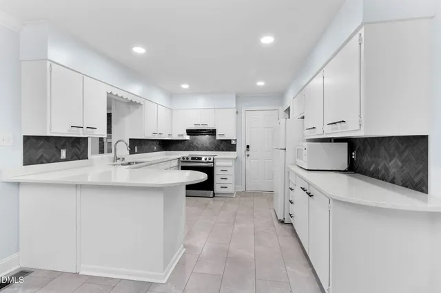 a kitchen with kitchen island a sink stainless steel appliances and refrigerator