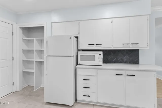 a kitchen with stainless steel appliances granite countertop a stove a sink and white cabinets