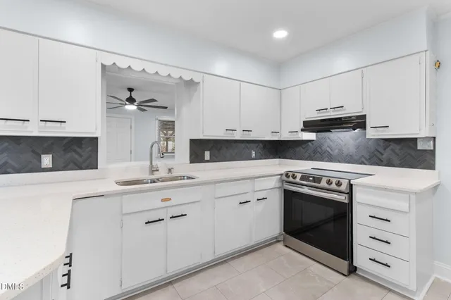 a view of cabinets with stainless steel appliances granite countertop white cabinet and a refrigerator