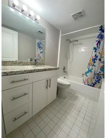 a bathroom with a granite countertop sink mirror and toilet