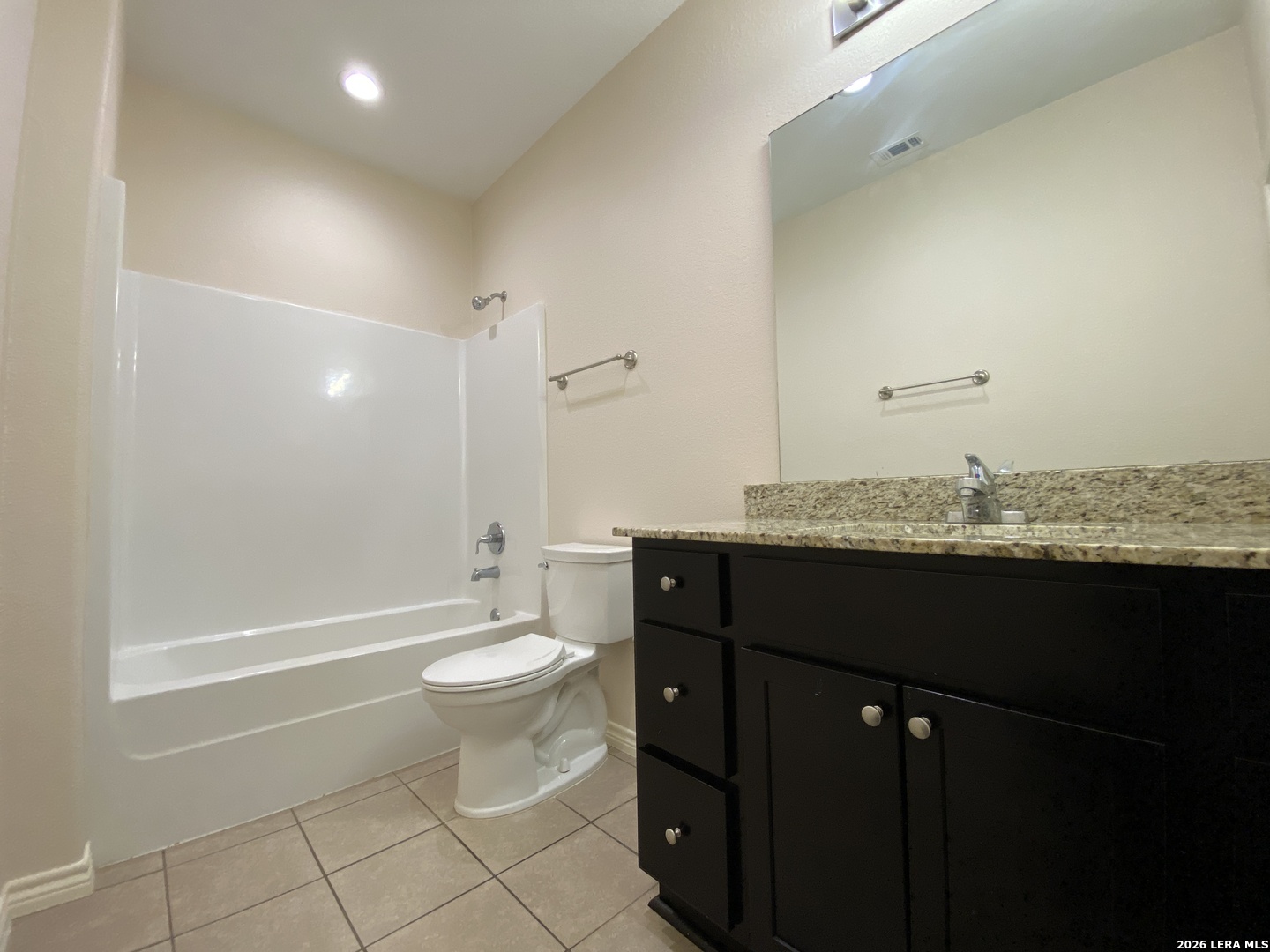 629 Commerce Street Pleasanton, TX 78064 - Photo 11 of 11 a bathroom with a granite countertop sink toilet and shower