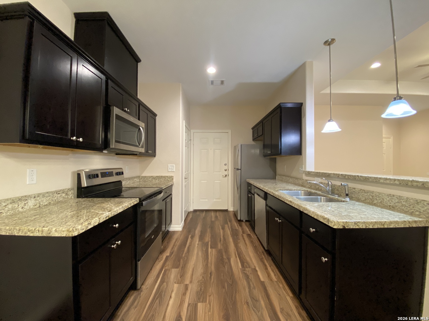 629 Commerce Street Pleasanton, TX 78064 - Photo 4 of 11 a large kitchen with granite countertop stainless steel appliances and a sink