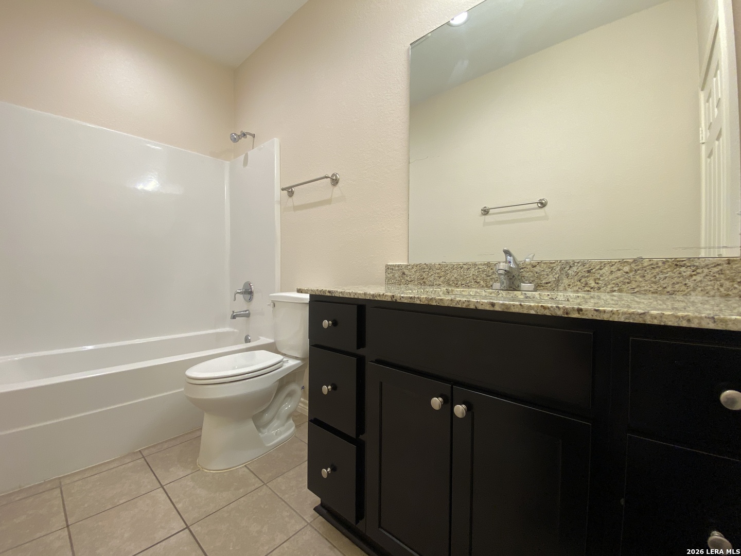 629 Commerce Street Pleasanton, TX 78064 - Photo 7 of 11 a bathroom with a granite countertop toilet sink and mirror