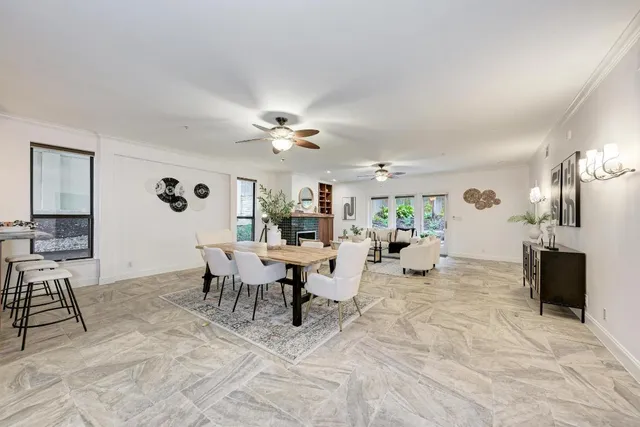 a living room with furniture a fireplace and a chandelier