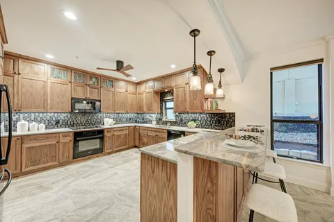 a living room with a fireplace windows and a potted plant