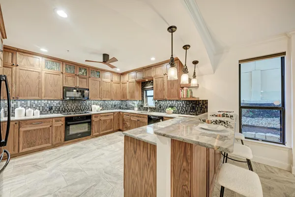 a living room with a fireplace windows and a potted plant