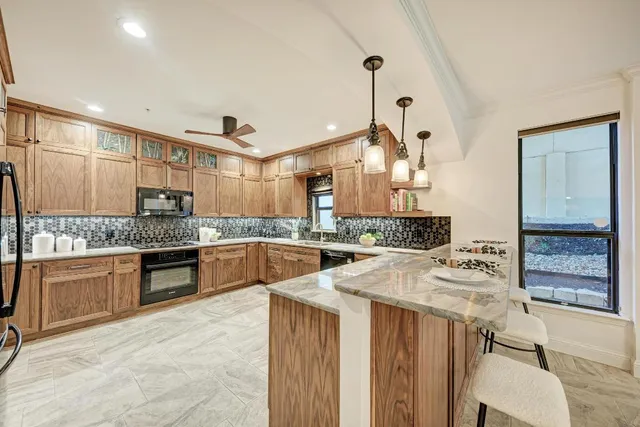 a living room with a fireplace windows and a potted plant