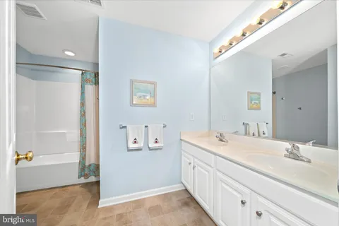 a bathroom with a double vanity sink a mirror and a bathtub