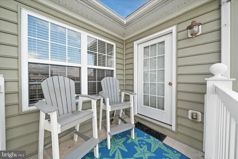 a view of front door with chair and wooden floor