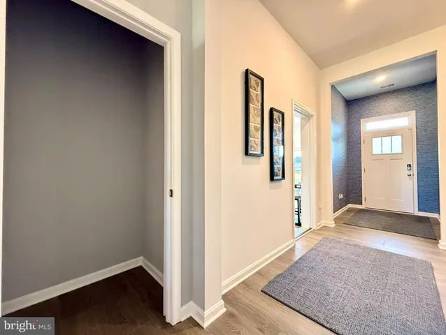 a view of a hallway with wooden floor and closet