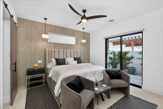 a bedroom with a balcony a bed and a window