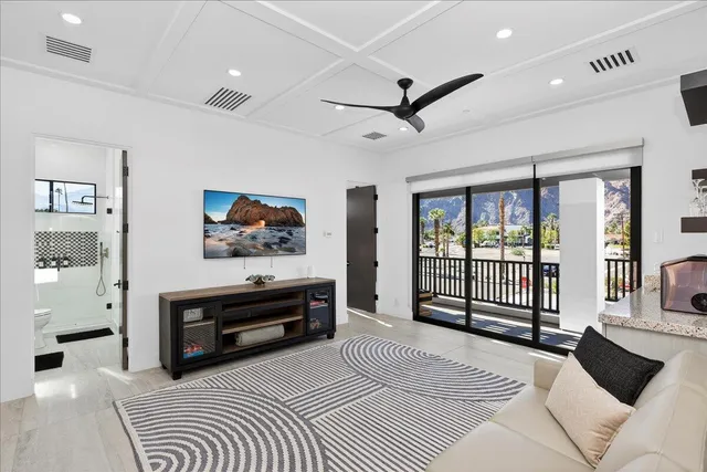 a view of a patio with table and chairs potted plants with floor to ceiling window