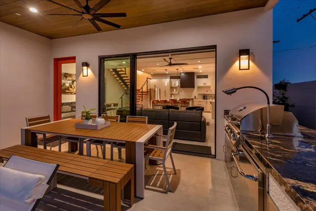 a kitchen with stainless steel appliances a stove a refrigerator a sink a dining table and chairs