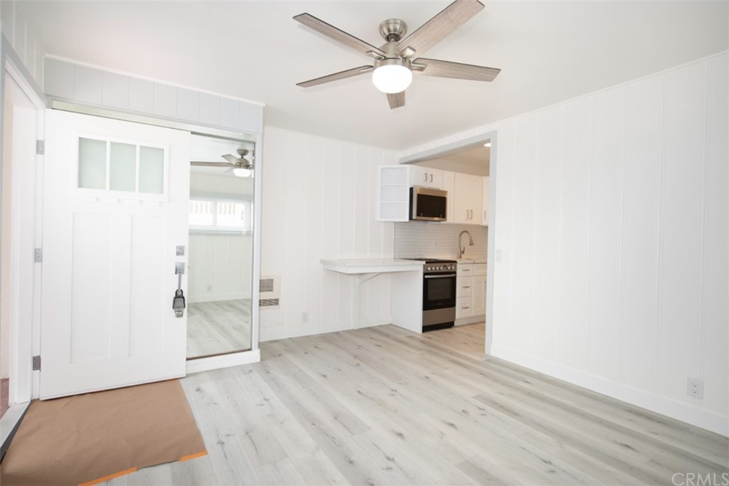 319 Cypress Drive, Unit B Laguna Beach, CA 92651 - Photo 6 of 39 a view of a kitchen with wooden floor and a ceiling fan
