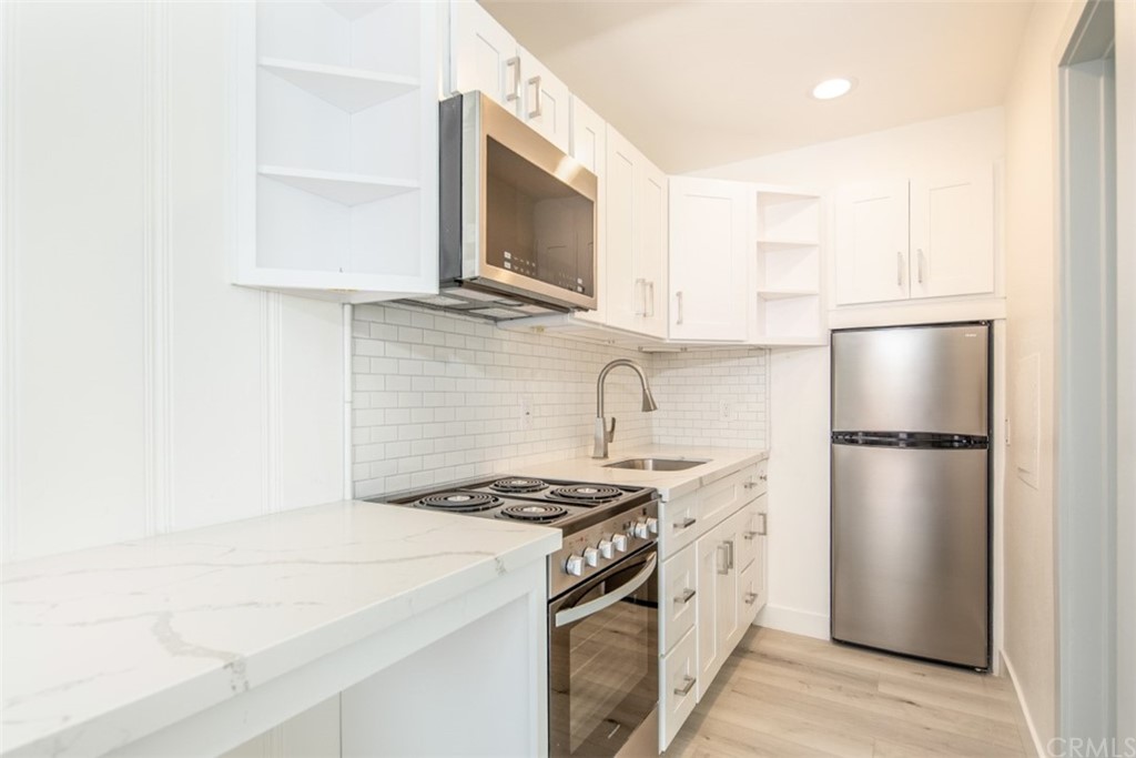 319 Cypress Drive, Unit B Laguna Beach, CA 92651 - Photo 9 of 39 a kitchen with a stove a refrigerator and a microwave