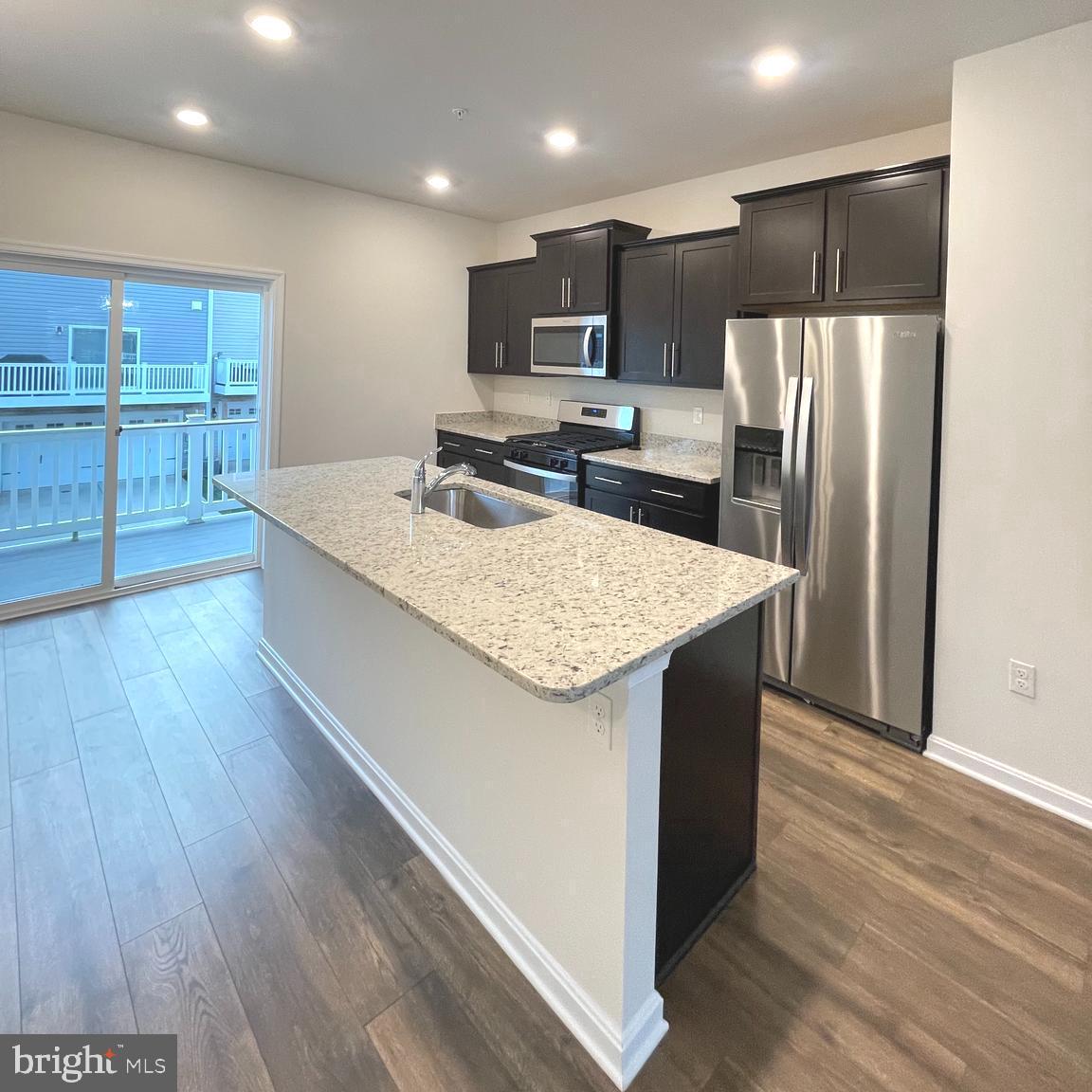 2709 Princess Victoria Way Bowie, MD 20721 - Photo 6 of 31 a kitchen with kitchen island granite countertop wooden cabinets refrigerator and microwave