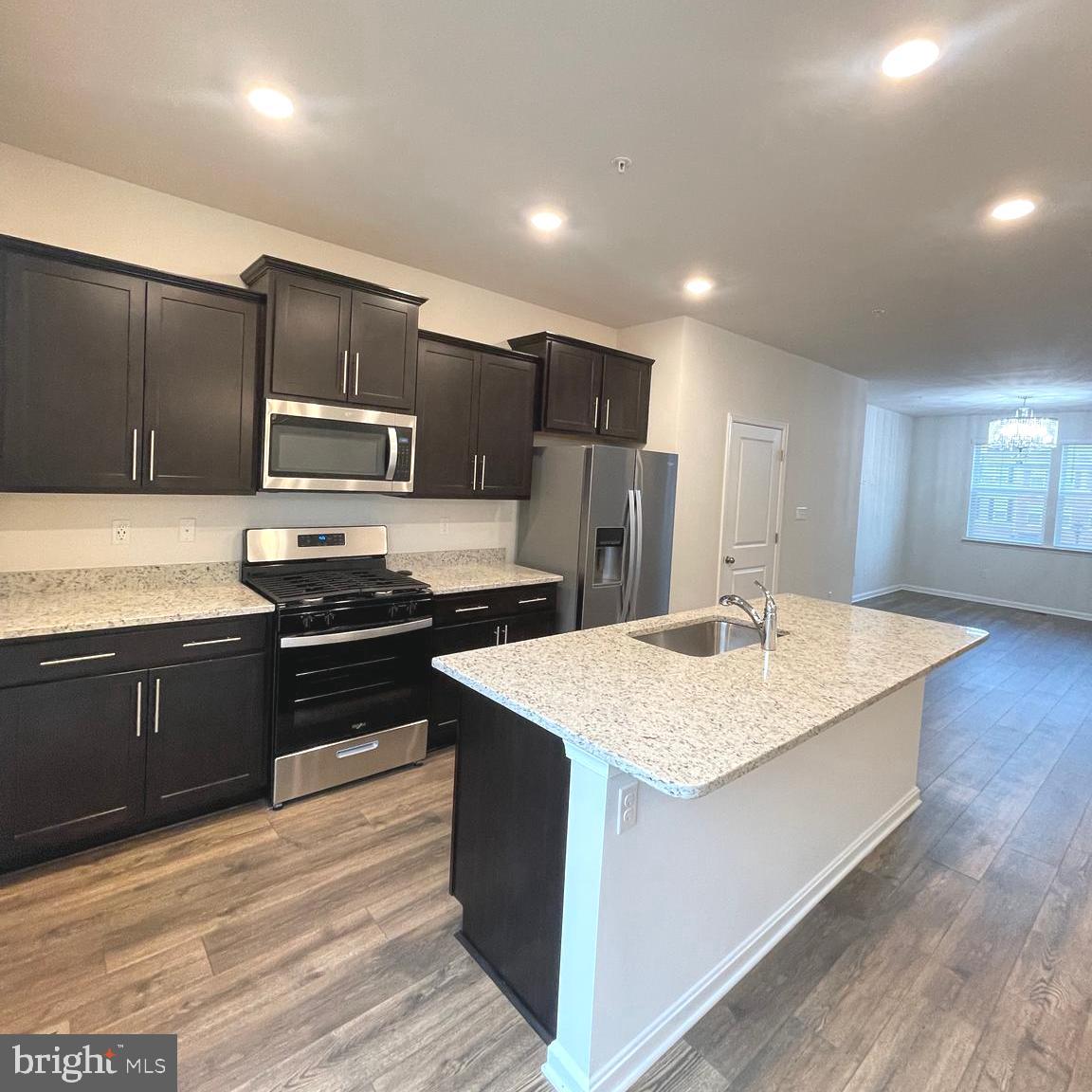 2709 Princess Victoria Way Bowie, MD 20721 - Photo 8 of 31 a kitchen with stainless steel appliances kitchen island granite countertop a refrigerator a stove and a sink with wooden floor