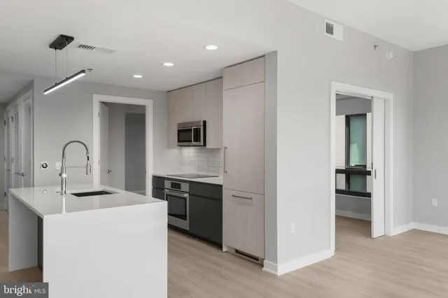 a view of a kitchen with a sink and dishwasher a refrigerator with wooden floor