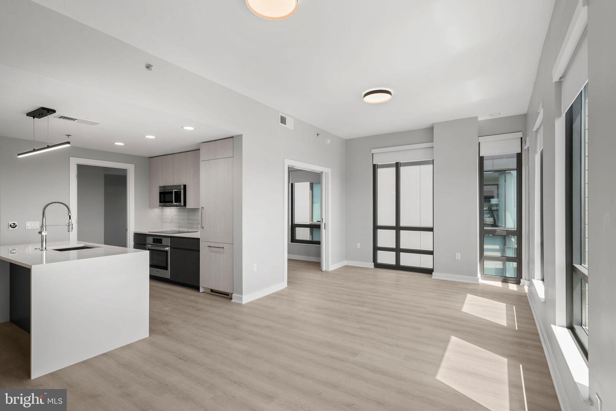 950 3rd Street Northwest, Unit PH1202 Washington, DC 20001 - Photo 30 of 45 a view of a kitchen with a sink and dishwasher a refrigerator with wooden floor