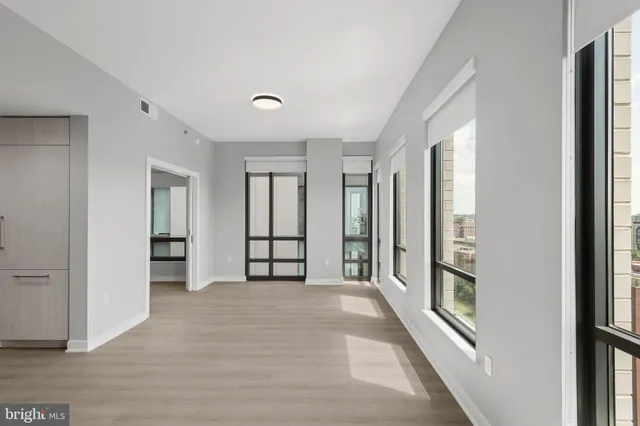 an empty room with windows and closet