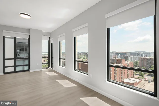 a view of an empty room with a window and closet area