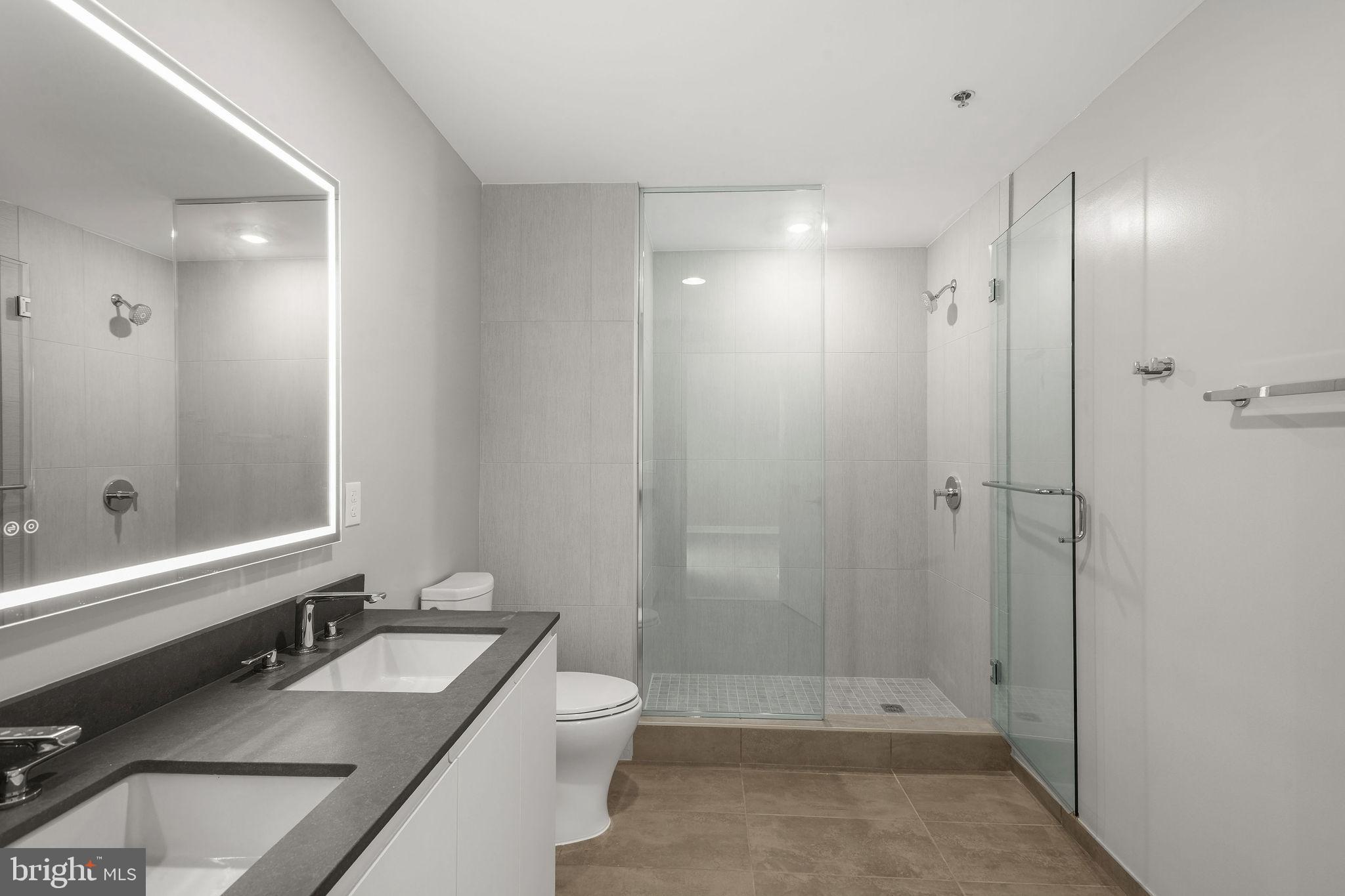 950 3rd Street Northwest, Unit PH1202 Washington, DC 20001 - Photo 38 of 45 a bathroom with a double vanity sink toilet and shower