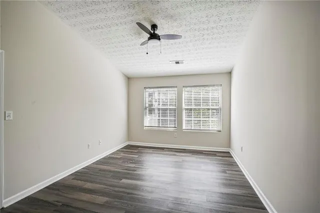 a view of an empty room with wooden floor and closet