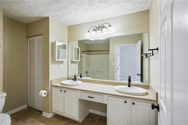 a bathroom with a granite countertop sink a toilet and shower
