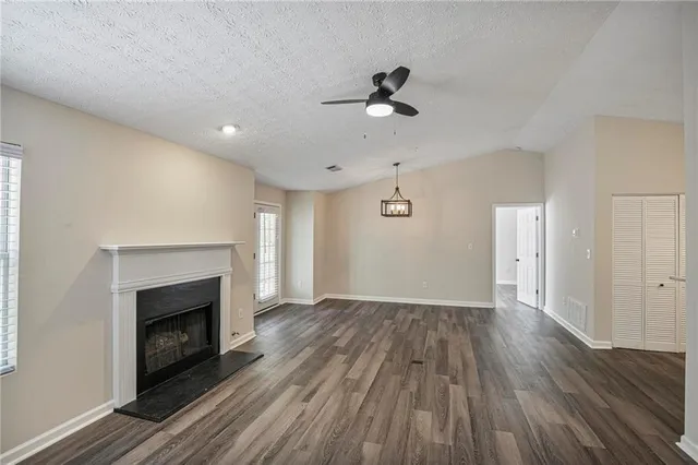 a view of a kitchen with a white kitchen space and wooden floor