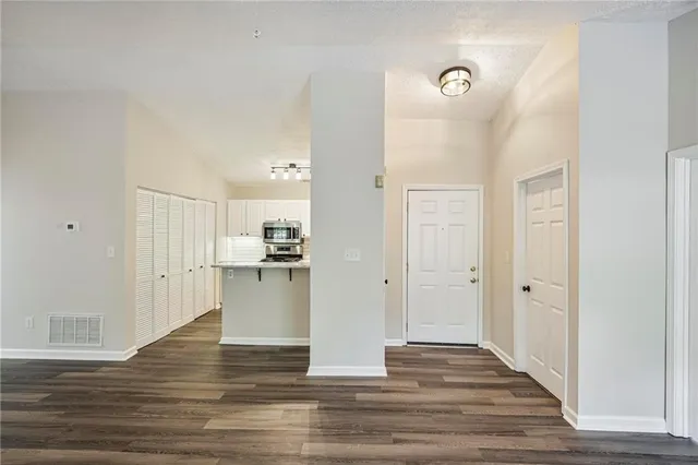 a kitchen with a refrigerator and white cabinets