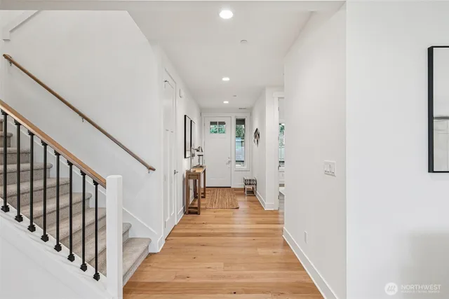a view of a hallway with wooden floor and staircase