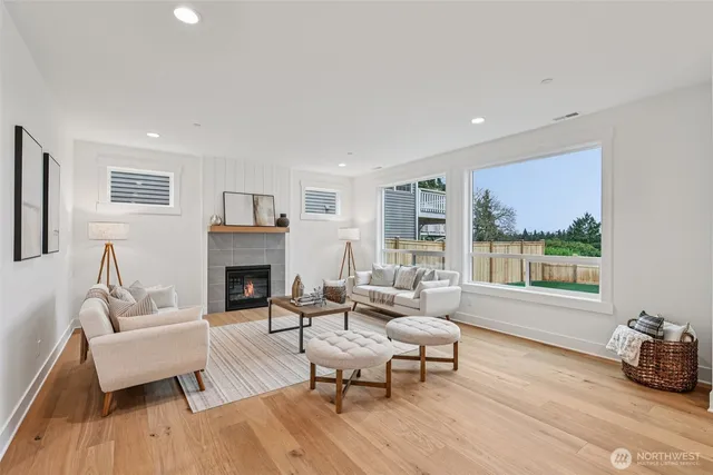 a living room with furniture a fireplace and a large window