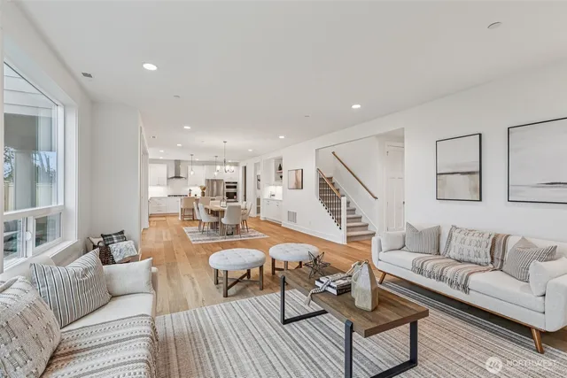 a living room with furniture and a dining table with wooden floor