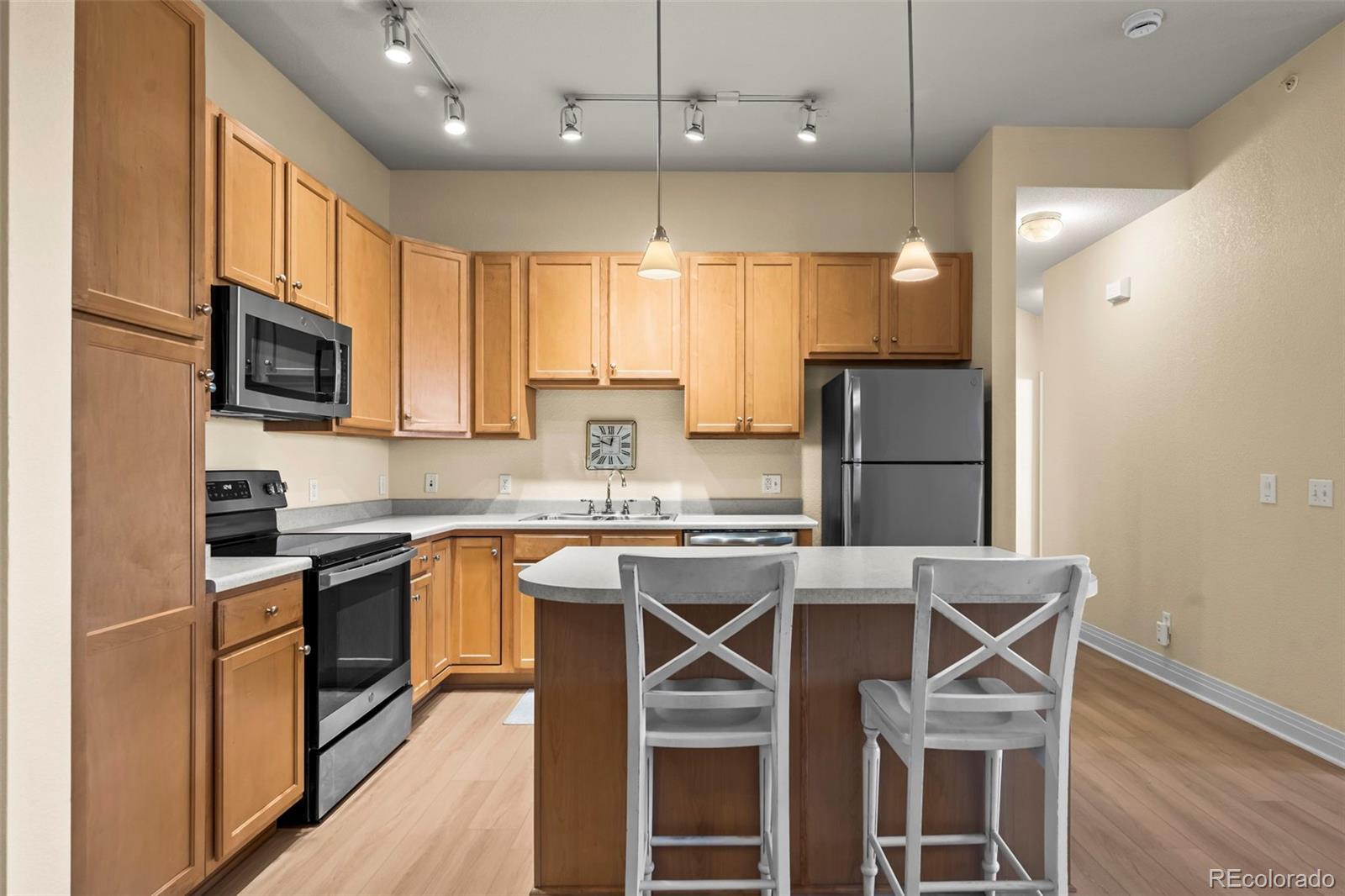 209 Quebec Street, Unit L Denver, CO 80220 - Photo 15 of 46 a kitchen with stainless steel appliances granite countertop a stove top oven a refrigerator a sink and dishwasher with white cabinets