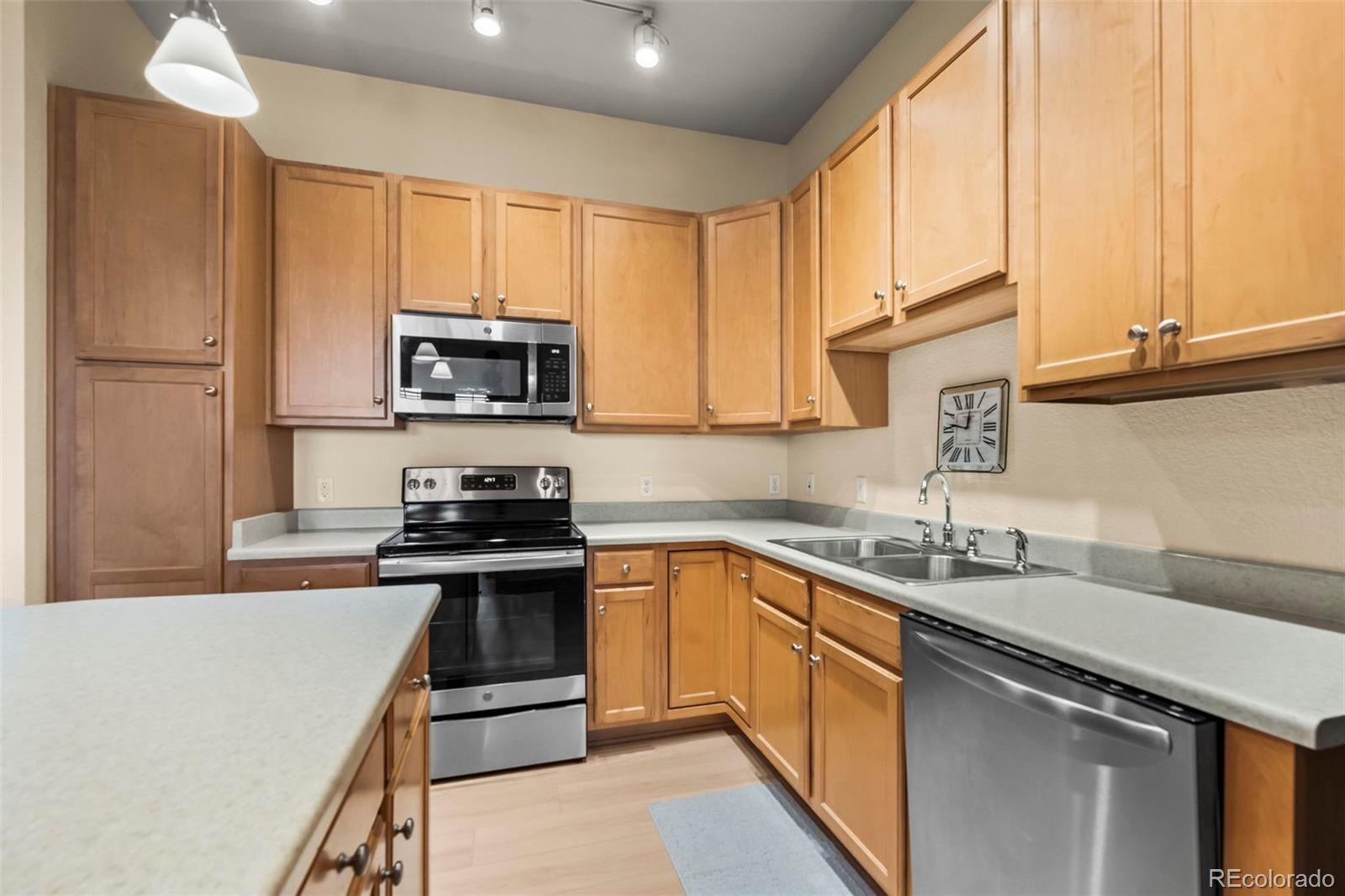 209 Quebec Street, Unit L Denver, CO 80220 - Photo 16 of 46 a kitchen with stainless steel appliances granite countertop a stove a sink dishwasher a refrigerator and a microwave