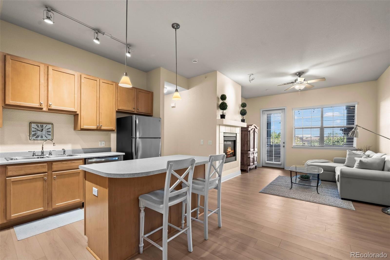 209 Quebec Street, Unit L Denver, CO 80220 - Photo 18 of 46 a kitchen with stainless steel appliances granite countertop a stove a refrigerator a kitchen island a dining table and chairs with wooden floor