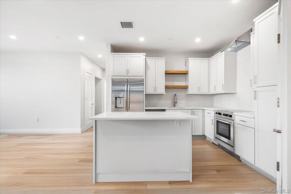 132 Halstead Avenue, Unit D Harrison, NY 10528 - Photo 3 of 19 a kitchen with stainless steel appliances granite countertop a stove top oven a sink and white cabinets