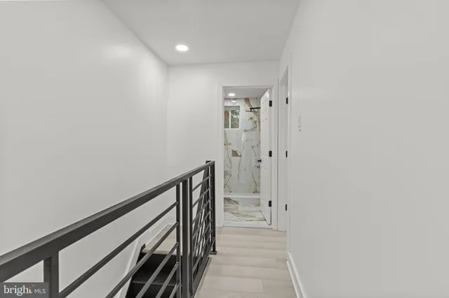 a view of a hallway with wooden floor and staircase