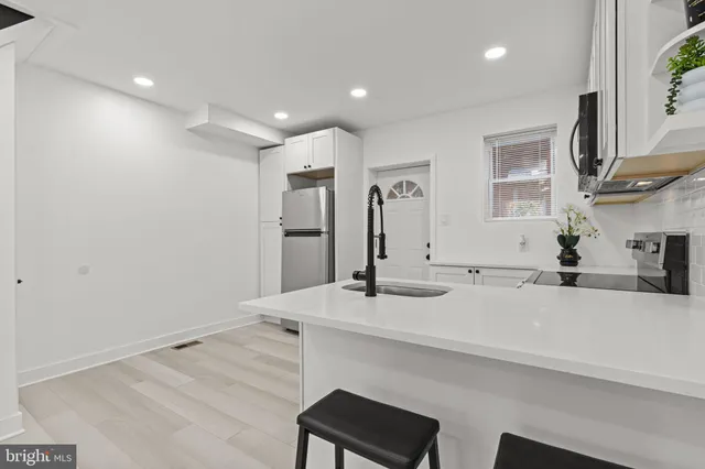 a view of a kitchen with granite countertop a sink and a refrigerator