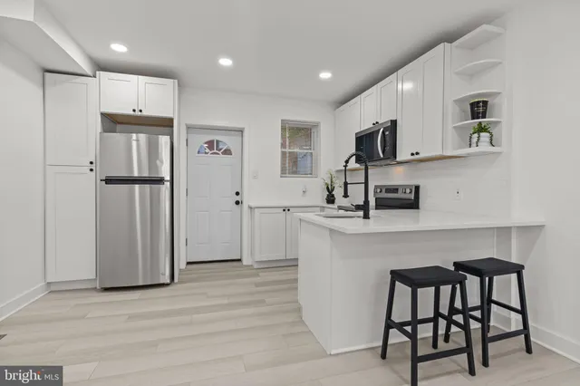 a kitchen with stainless steel appliances a refrigerator and a stove top oven