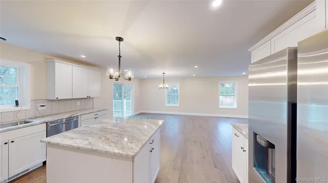 a kitchen with kitchen island a counter top space stainless steel appliances and a chandelier