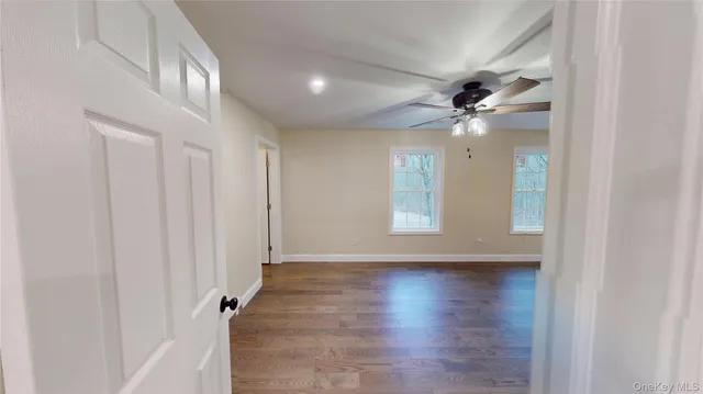an empty room with wooden floor and a window