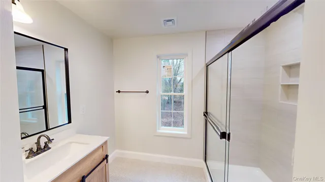 a view of a livingroom with wooden floor a ceiling fan and windows