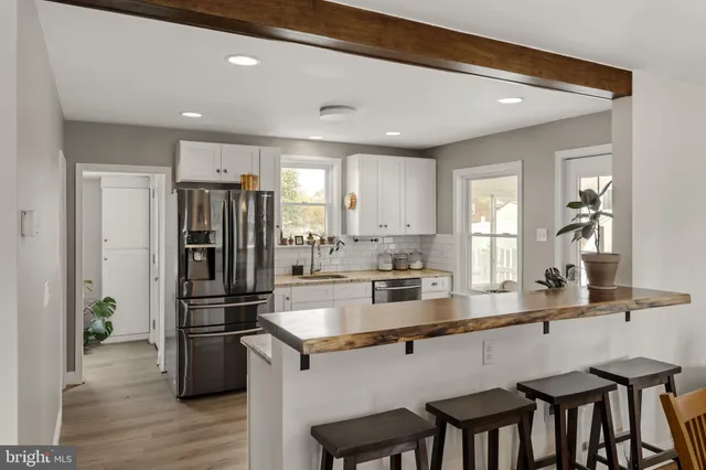 a kitchen with refrigerator a sink and chairs