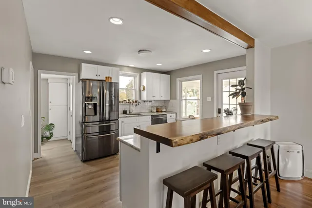 a kitchen with granite countertop a refrigerator and a stove top oven